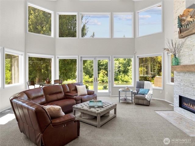 34214 102nd Ave S, Roy, WA 98580 - living room with a high ceiling, carpet flooring, a stone fireplace, and baseboards
