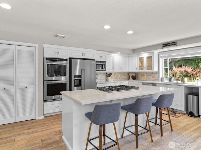 34214 102nd Ave S, Roy, WA 98580 - kitchen with stainless steel appliances, a sink, light wood-style flooring, white cabinetry, and recessed lighting