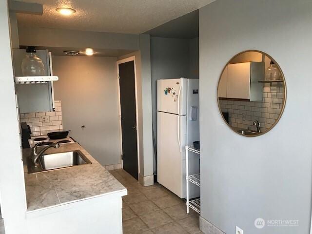 2513 13th Ave W, Seattle, WA 98119 - kitchen with freestanding refrigerator, tasteful backsplash, and light countertops