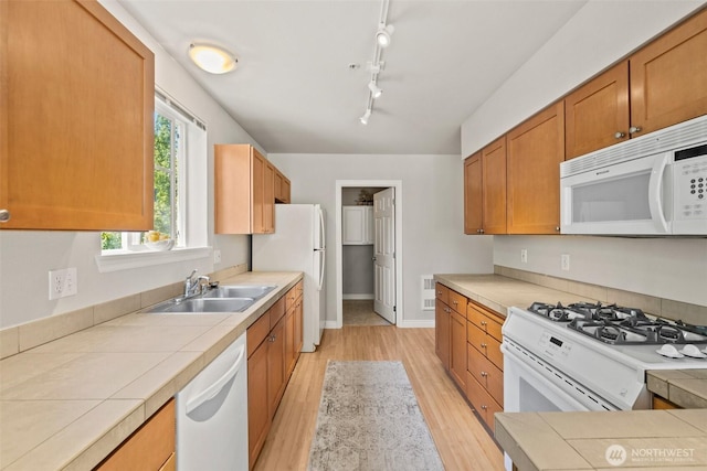 17432 Bothell Way NE Unit B302, Bothell, WA 98011 - kitchen featuring white appliances, light wood-style flooring, tile countertops, rail lighting, and brown cabinets