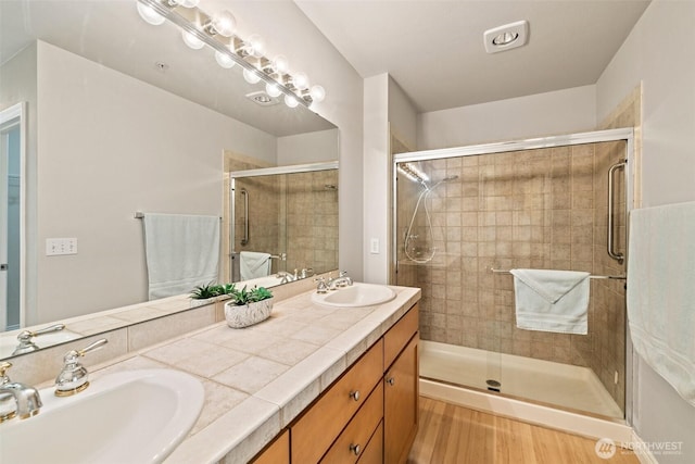 17432 Bothell Way NE Unit B302, Bothell, WA 98011 - bathroom featuring double vanity, a stall shower, and wood finished floors