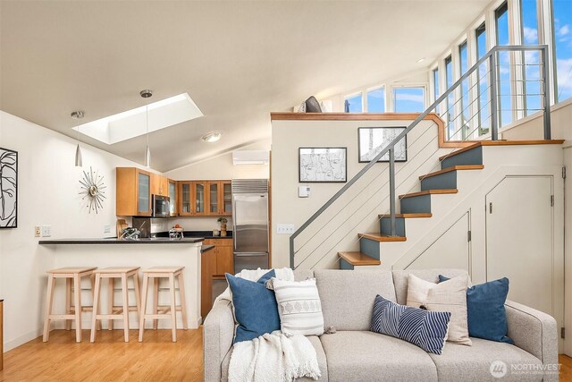 2420 Westlake Ave N Unit 11, Seattle, WA 98109 - living room with a skylight, light wood-type flooring, stairs, lofted ceiling, and a wall mounted AC
