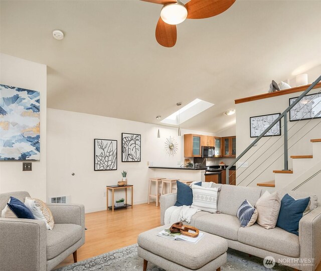 2420 Westlake Ave N Unit 11, Seattle, WA 98109 - living room featuring a skylight, light wood-style floors, stairs, and a ceiling fan