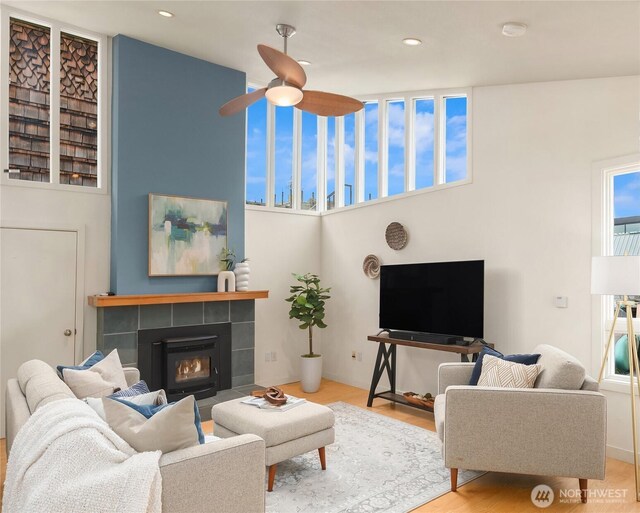 2420 Westlake Ave N Unit 11, Seattle, WA 98109 - living room featuring a ceiling fan, a tile fireplace, wood finished floors, and recessed lighting