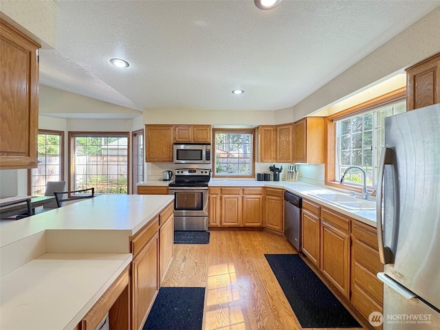 42 Charles Way, Sequim, WA 98382 - kitchen with appliances with stainless steel finishes, a sink, light wood-type flooring, a textured ceiling, and light countertops
