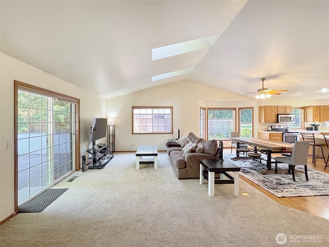 42 Charles Way, Sequim, WA 98382 - living room with lofted ceiling, light colored carpet, plenty of natural light, and a skylight