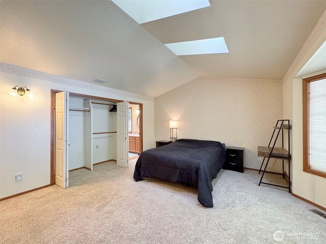 42 Charles Way, Sequim, WA 98382 - bedroom featuring a skylight, light colored carpet, vaulted ceiling, baseboards, and ensuite bath