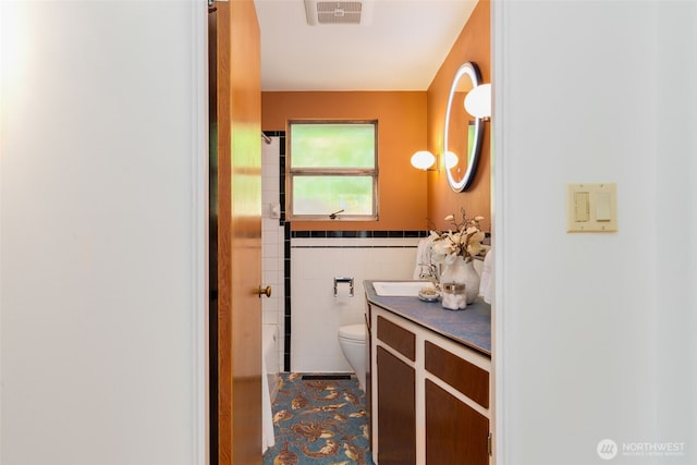 7008 25th Ave NE, Seattle, WA 98115 - bathroom with toilet, vanity, tile walls, and wainscoting