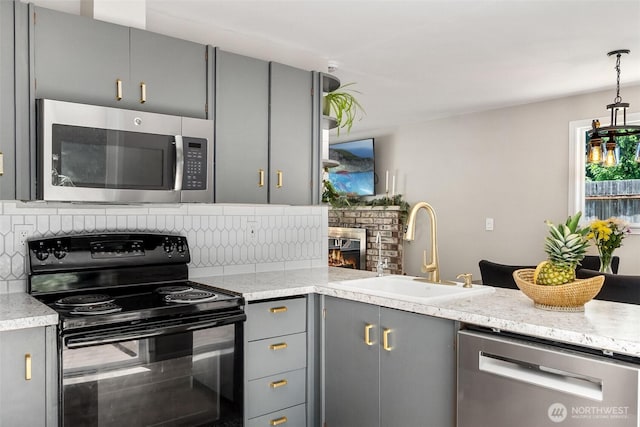 9541 Joann Ave NE, Olympia, WA 98516 - kitchen with appliances with stainless steel finishes, gray cabinetry, backsplash, a fireplace, and pendant lighting