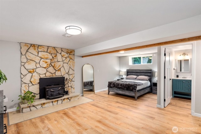 9541 Joann Ave NE, Olympia, WA 98516 - bedroom featuring a wood stove, light wood-type flooring, arched walkways, and connected bathroom