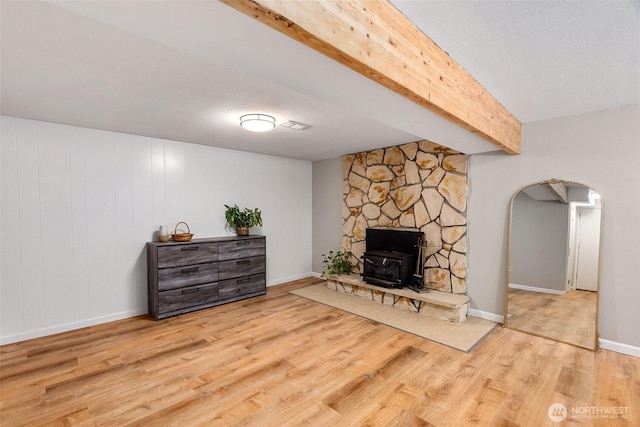 9541 Joann Ave NE, Olympia, WA 98516 - living room with arched walkways, wood finished floors, beam ceiling, and a wood stove
