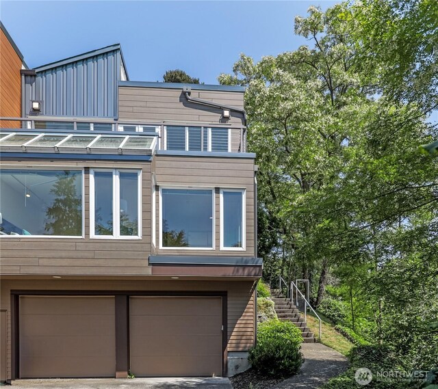 101 NW 58th St Unit 9, Seattle, WA 98107 - view of property exterior with an attached garage, stairs, and a balcony