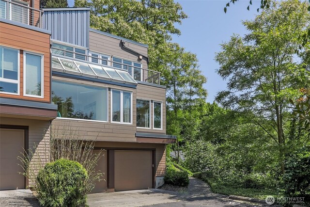 101 NW 58th St Unit 9, Seattle, WA 98107 - view of home's exterior featuring an attached garage, driveway, and a balcony