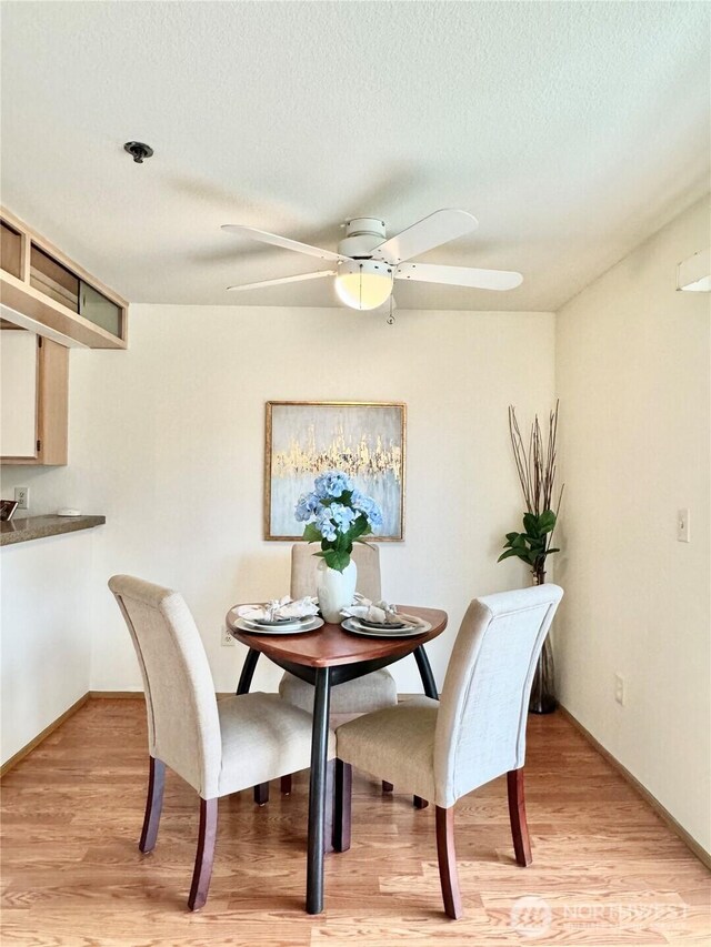 28606 16th Ave S Unit 102, Federal Way, WA 98003 - dining area featuring a ceiling fan, light wood-style floors, a textured ceiling, and baseboards