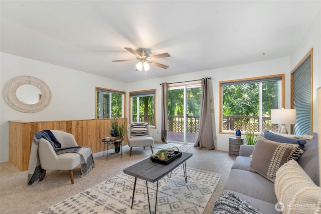 5810 E Mason Lake Dr W, Grapeview, WA 98546 - carpeted living area featuring a ceiling fan, wood walls, and wainscoting