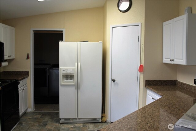 153 NW Quincy Pl, Soap Lake, WA 98851 - kitchen with white refrigerator with ice dispenser, washer and clothes dryer, black / electric stove, white cabinets, and lofted ceiling