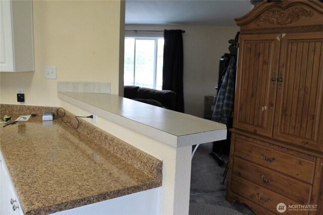 153 NW Quincy Pl, Soap Lake, WA 98851 - kitchen featuring a peninsula and white cabinetry
