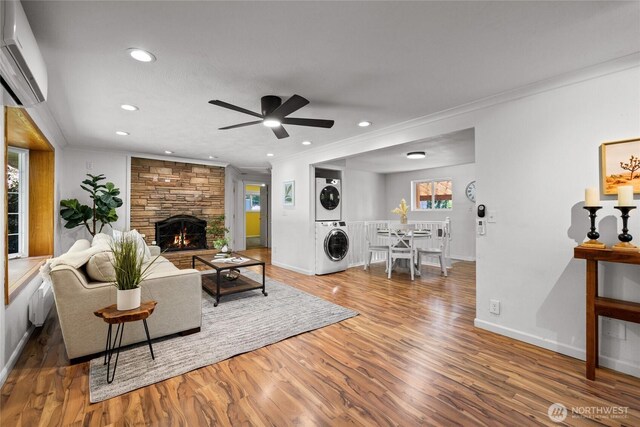 1315 SW 310th St, Federal Way, WA 98023 - living room featuring stacked washer / dryer, a wall mounted AC, ornamental molding, wood finished floors, and a ceiling fan