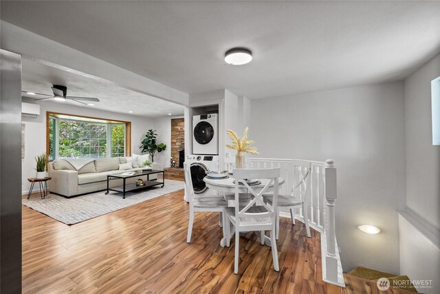 1315 SW 310th St, Federal Way, WA 98023 - dining space featuring stacked washer and clothes dryer, an AC wall unit, wood finished floors, and ceiling fan