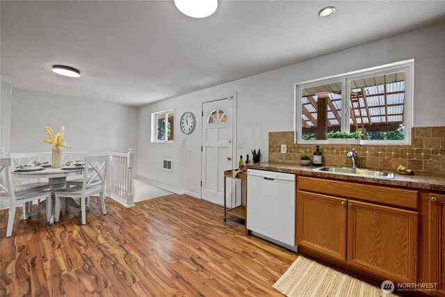 1315 SW 310th St, Federal Way, WA 98023 - kitchen featuring dishwasher, a sink, light wood-style floors, brown cabinetry, and tasteful backsplash