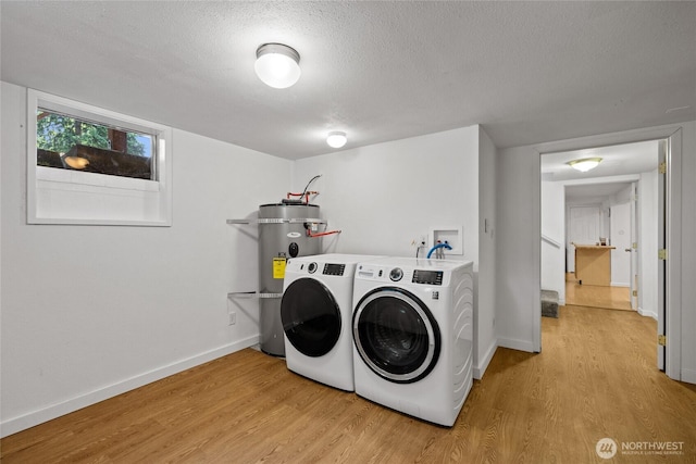 1315 SW 310th St, Federal Way, WA 98023 - washroom featuring water heater, light wood finished floors, baseboards, a textured ceiling, and washer and clothes dryer
