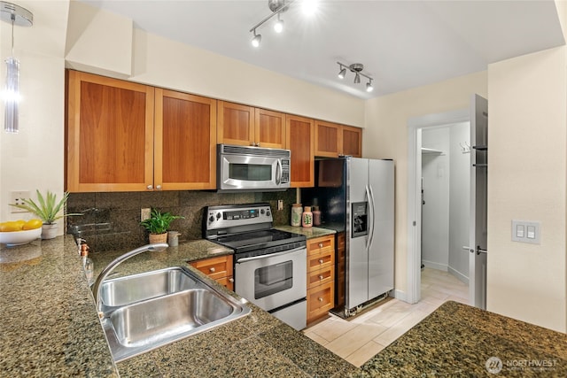 1545 NW 57th St Unit 220, Seattle, WA 98107 - kitchen with stainless steel appliances, a sink, brown cabinetry, tasteful backsplash, and light tile patterned floors