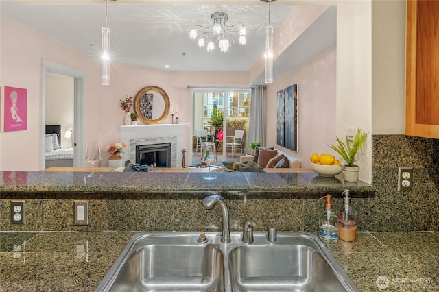 1545 NW 57th St Unit 220, Seattle, WA 98107 - kitchen featuring a sink, tile counters, backsplash, and a fireplace