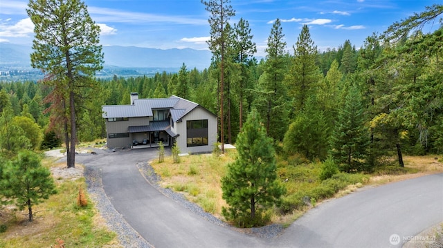 1450 Creekside Rd, Cle Elum, WA 98922 - view of front of home with a view of trees, a chimney, metal roof, a mountain view, and a standing seam roof