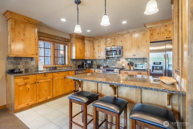 3770 Suncadia Trl Unit 110, Cle Elum, WA 98922 - kitchen with stainless steel appliances, a sink, backsplash, a breakfast bar, and decorative light fixtures