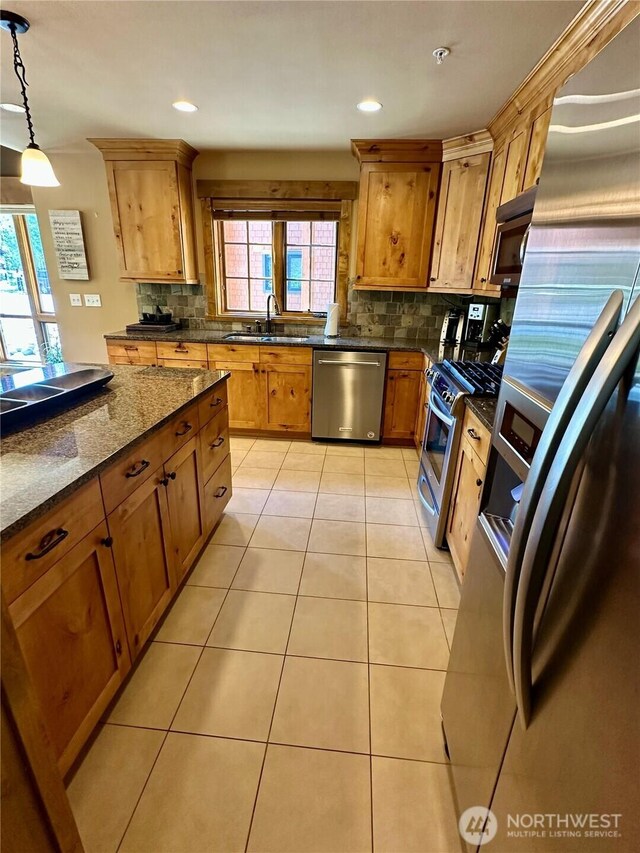 3770 Suncadia Trl Unit 110, Cle Elum, WA 98922 - kitchen with stainless steel appliances, backsplash, decorative light fixtures, a sink, and dark stone countertops