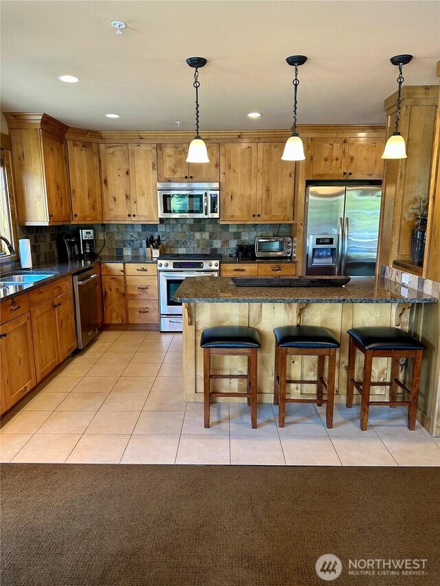 3770 Suncadia Trl Unit 110, Cle Elum, WA 98922 - kitchen with stainless steel appliances, a sink, decorative light fixtures, and a kitchen breakfast bar