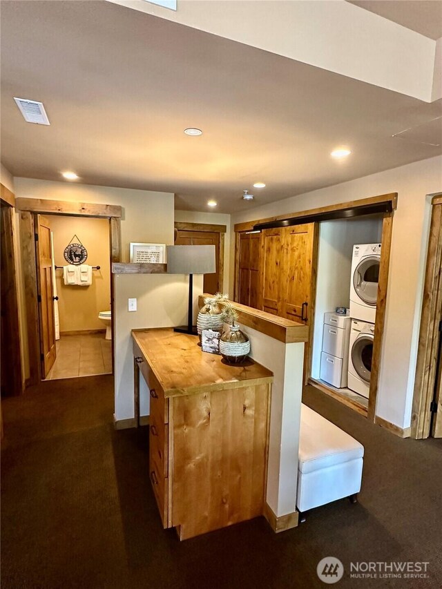 3770 Suncadia Trl Unit 110, Cle Elum, WA 98922 - kitchen with butcher block countertops, stacked washing machine and dryer, dark colored carpet, brown cabinets, and recessed lighting