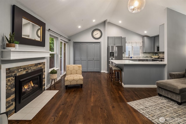 14566 86th Pl NE, Kenmore, WA 98028 - living room featuring dark wood-style floors, a fireplace, high vaulted ceiling, recessed lighting, and baseboards