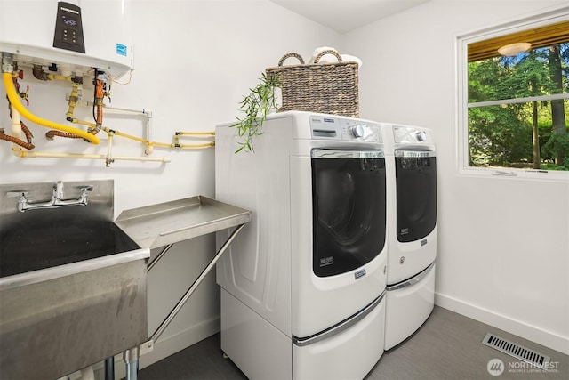 5619 89th Ave SE, Mercer Island, WA 98040 - washroom with washing machine and clothes dryer, baseboards, water heater, and dark wood finished floors