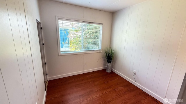 42010 SE N Bend Way Unit 29, North Bend, WA 98045 - unfurnished bedroom with dark wood-type flooring, wood walls, and baseboards