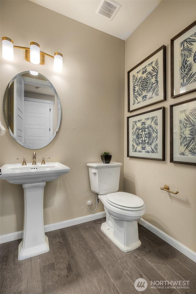 20320 150th St E, Bonney Lake, WA 98391 - half bathroom with wood finished floors, toilet, baseboards, and a sink