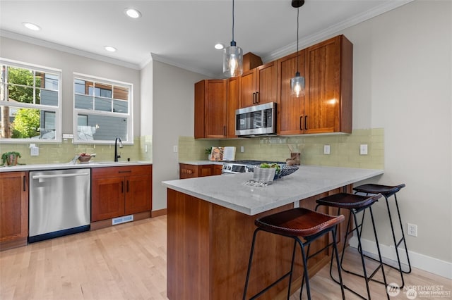 31 Etruria St Unit B, Seattle, WA 98109 - kitchen featuring appliances with stainless steel finishes, brown cabinets, a peninsula, light wood finished floors, and recessed lighting