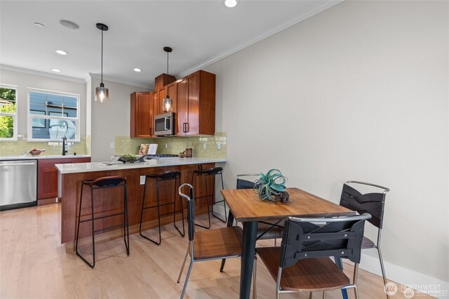 31 Etruria St Unit B, Seattle, WA 98109 - kitchen featuring appliances with stainless steel finishes, ornamental molding, tasteful backsplash, light countertops, and a sink