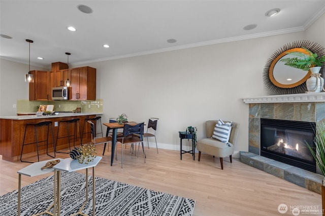 31 Etruria St Unit B, Seattle, WA 98109 - living room with light wood-type flooring, crown molding, a fireplace, baseboards, and recessed lighting