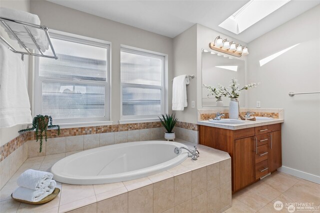31 Etruria St Unit B, Seattle, WA 98109 - bathroom with vanity, a skylight, a garden tub, and tile patterned flooring