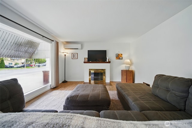 1511 Howard St, Walla Walla, WA 99362 - living area featuring a wall mounted air conditioner, wood finished floors, a brick fireplace, and baseboards