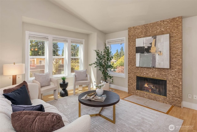 12422 2nd Ave SW, Burien, WA 98146 - living room featuring light wood finished floors, lofted ceiling, a tiled fireplace, and baseboards