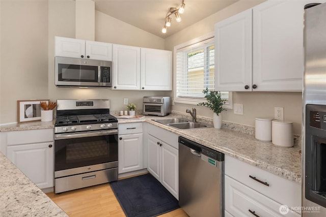 12422 2nd Ave SW, Burien, WA 98146 - kitchen with appliances with stainless steel finishes, a sink, lofted ceiling, white cabinets, and light wood finished floors