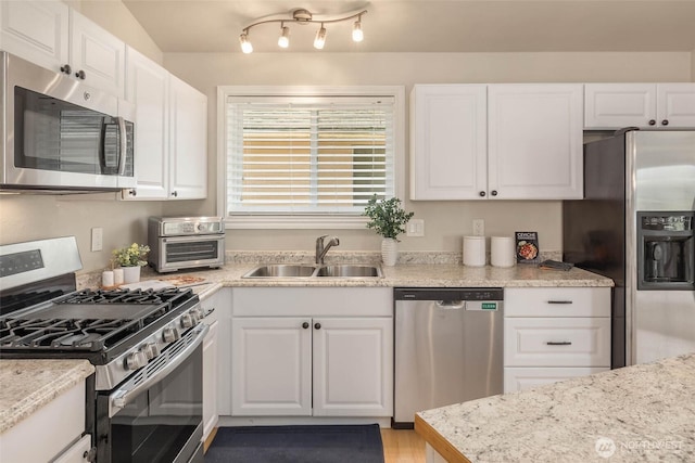 12422 2nd Ave SW, Burien, WA 98146 - kitchen with appliances with stainless steel finishes, a sink, white cabinetry, and light wood finished floors