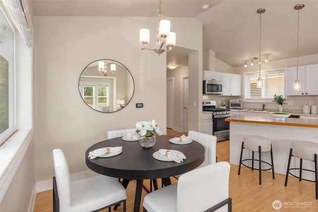 12422 2nd Ave SW, Burien, WA 98146 - dining area featuring a chandelier, vaulted ceiling, healthy amount of natural light, and light wood finished floors