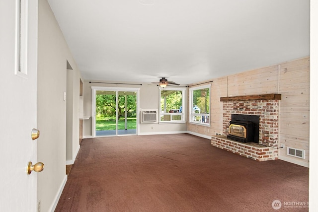 924 1st St, Sultan, WA 98294 - unfurnished living room with a wood stove, dark colored carpet, ceiling fan, and baseboards