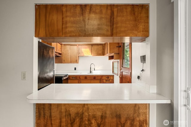 924 1st St, Sultan, WA 98294 - kitchen featuring range, under cabinet range hood, light countertops, and brown cabinetry