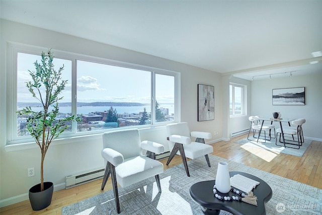 919 2nd Ave W Unit 601, Seattle, WA 98119 - living area featuring baseboard heating, wood finished floors, baseboards, and a water view