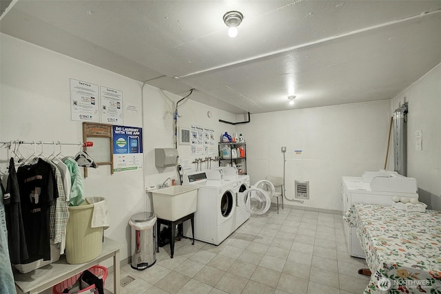 919 2nd Ave W Unit 601, Seattle, WA 98119 - communal laundry room with separate washer and dryer, heating unit, and light tile patterned floors