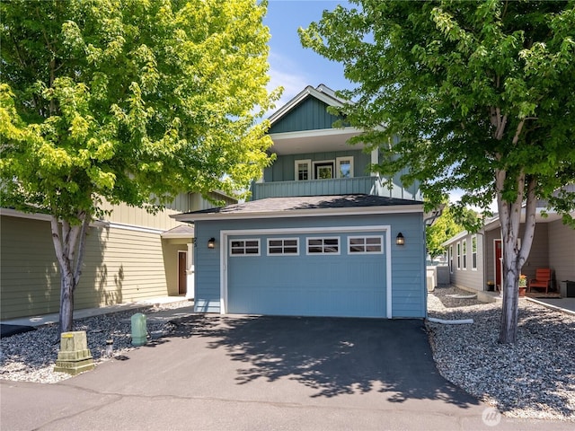 2452 NW Columbia Ave Unit 25, East Wenatchee, WA 98802 - view of front of home with board and batten siding, a balcony, a garage, and asphalt driveway